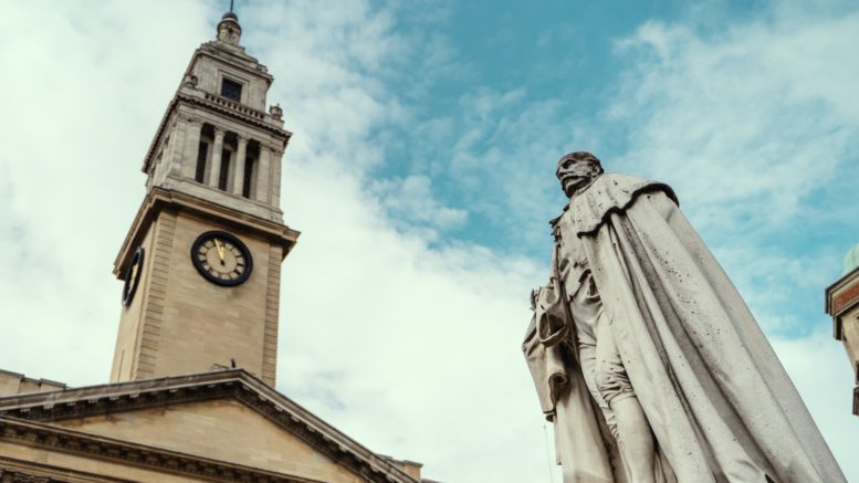 An image of a statue and Hull's Guildhall